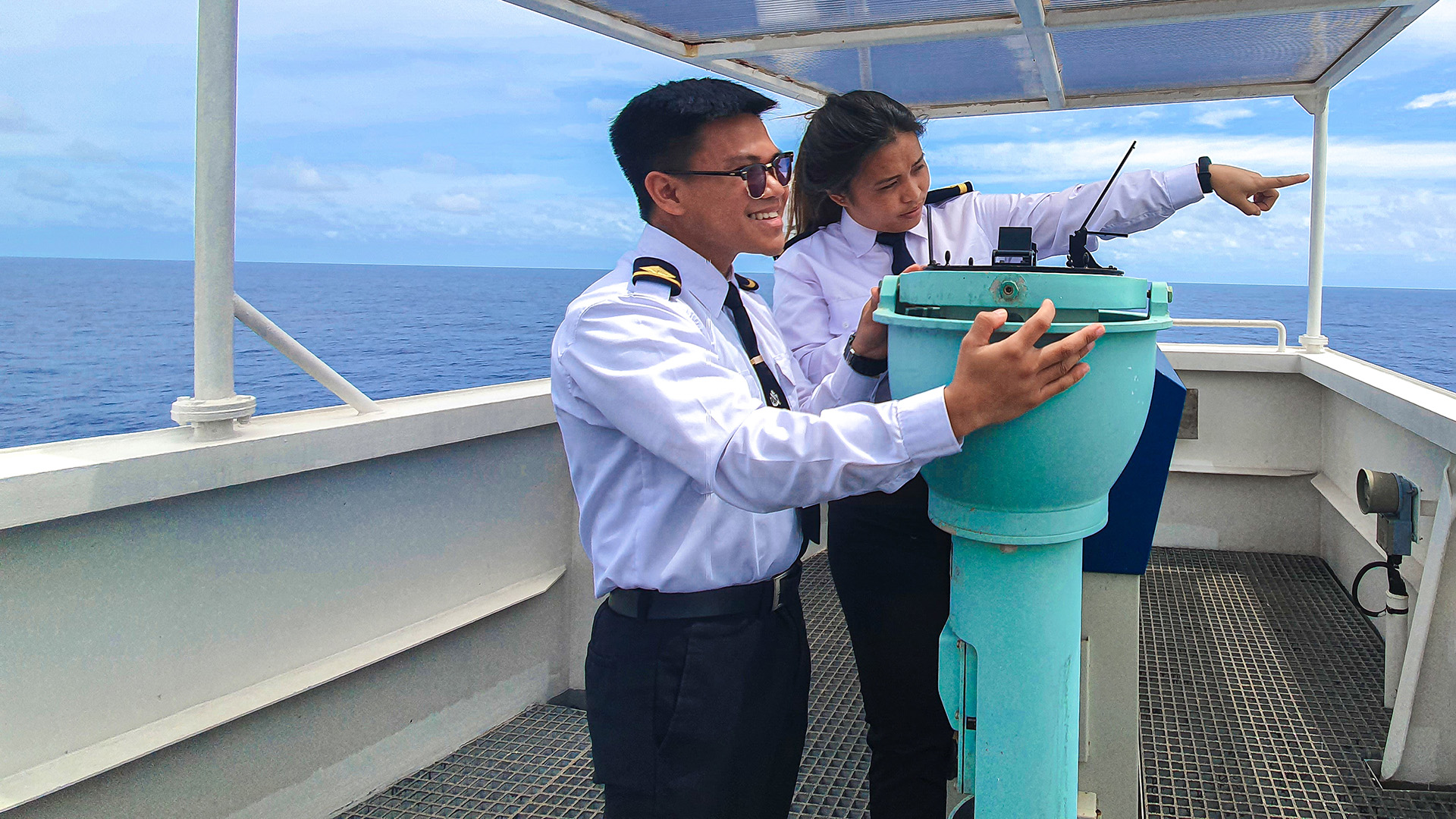 A male and female employee in uniform onboard a ship.